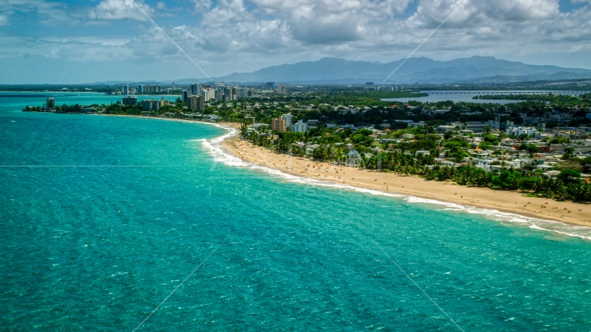 Beachfront homes beside beaches with tourists and crystal blue water, San Juan, Puerto Rico Aerial Stock Photo AX102_005.0000000F | Axiom Images