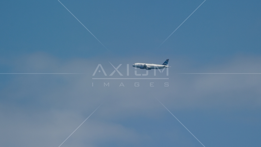A passenger plane and blue skies, Carolina, Puerto Rico Aerial Stock Photos AX102_014.0000199F | Axiom Images