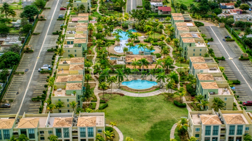 Flying by vacation rentals and pools on the grounds in Loiza, Puerto Rico Aerial Stock Photo AX102_037.0000090F | Axiom Images