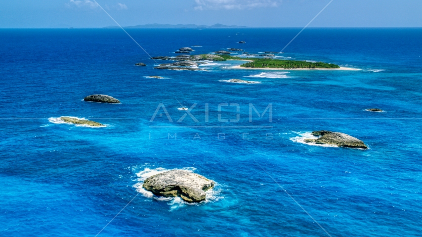 Tiny green Caribbean island in tropical blue waters, and smaller rocky islands, Puerto Rico Aerial Stock Photo AX102_088.0000024F | Axiom Images