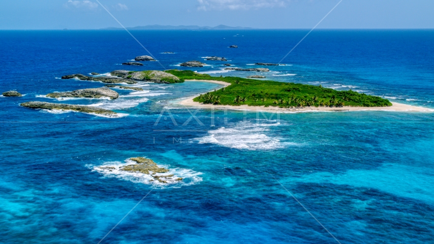 A green island surrounded by smaller rocky islands and tropical blue waters, Puerto Rico Aerial Stock Photo AX102_088.0000259F | Axiom Images