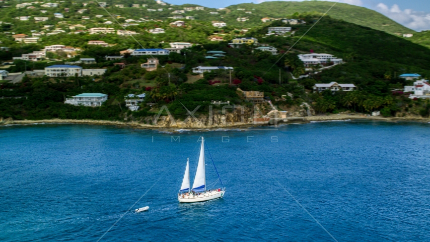 Sailboat near the island coast and oceanfront homes in Southside, St Thomas, the US Virgin Islands Aerial Stock Photo AX102_234.0000199F | Axiom Images