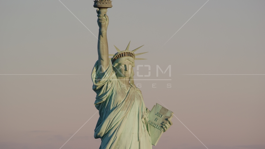 The front of the Statue of Liberty at sunrise in New York Aerial Stock Photos AX118_107.0000082F