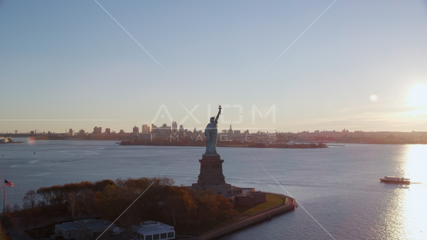 Statue of Liberty and Brooklyn across the harbor at sunrise in New York Aerial Stock Photos AX118_118.0000187F | Axiom Images