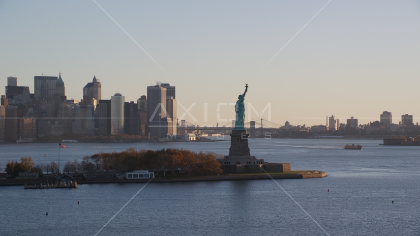 Statue of Liberty and Lower Manhattan skyscrapers at sunrise in New York City Aerial Stock Photos AX118_132.0000000F