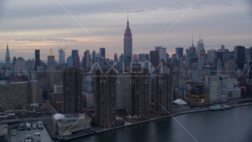 Empire State Building seen from riverfront apartment buildings at sunset in New York City Aerial Stock Photos AX121_049.0000000F