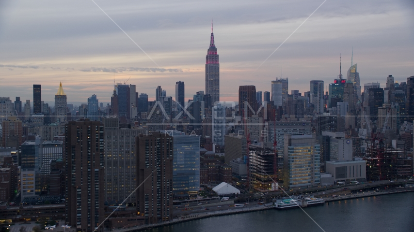 Empire State Building seen from riverfront office and apartment buildings at sunset in New York City Aerial Stock Photo AX121_049.0000187F | Axiom Images