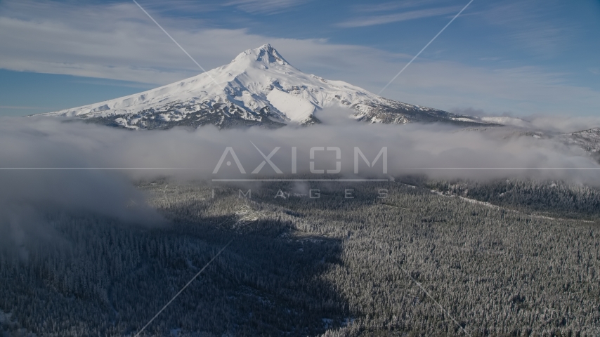 Snowy mountain peak with low clouds over forest, Mount Hood, Cascade Range, Oregon Aerial Stock Photos AX154_118.0000000F