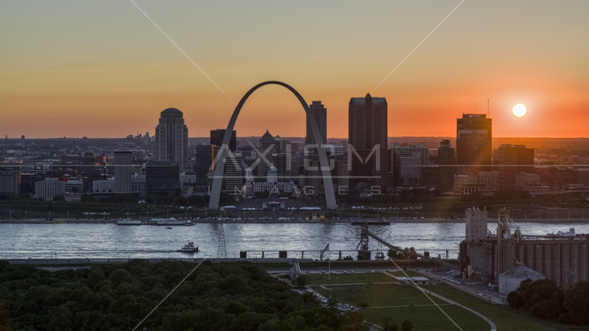 The setting sun behind the Gateway Arch and Downtown St. Louis, Missouri Aerial Stock Photos DXP001_029_0005