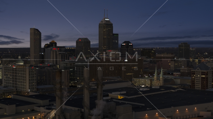 Giant skyscrapers of the city skyline at twilight, seen from smoke stacks, Downtown Indianapolis, Indiana Aerial Stock Photos DXP001_093_005