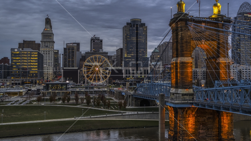 The Roebling Bridge near the Ferris wheel and city skyline at sunset, Downtown Cincinnati, Ohio Aerial Stock Photos DXP001_097_0014