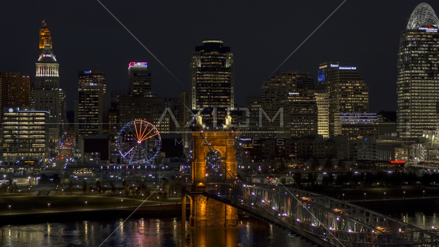 The Ferris wheel by Roebling Bridge at night, with city skyline in background, Downtown Cincinnati, Ohio Aerial Stock Photos DXP001_098_0023
