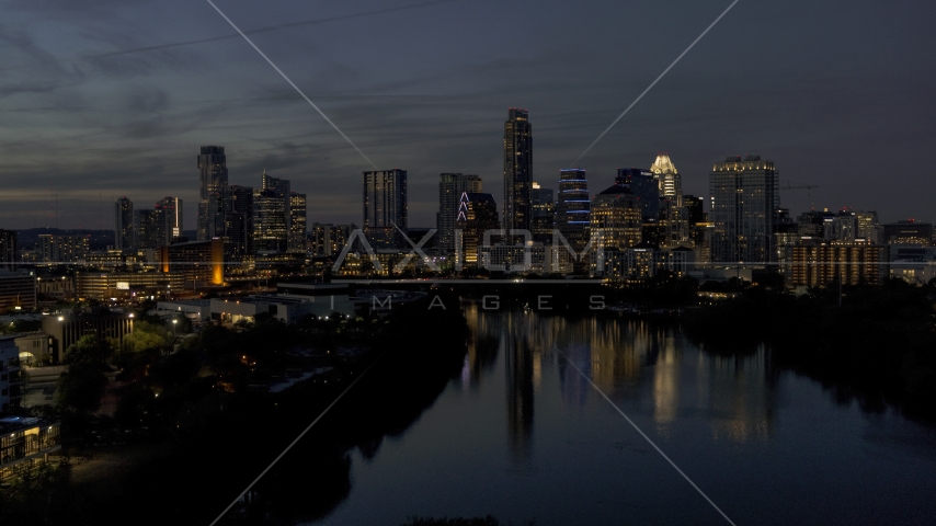 A view of Lady Bird Lake, focus on the waterfront skyline at twilight in Downtown Austin, Texas Aerial Stock Photo DXP002_111_0001 | Axiom Images
