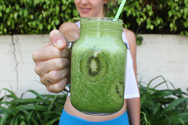 Woman holding green Shakeology shake