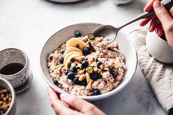 Mujer comiendo avena con fruta