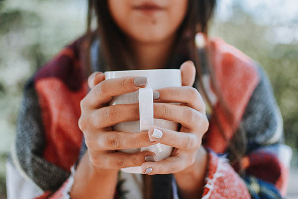 Woman holding mug of hot tea