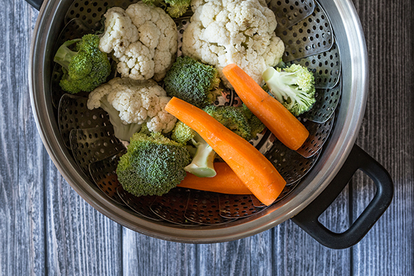 Fresh vegetables steamed on a wooden table