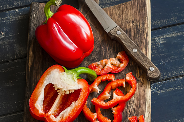 Fresh sweet red pepper on a wooden board