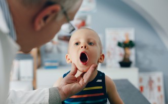 Cute Caucasian boy examined at the doctor's.