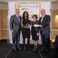 Dr. Nicole accepts the Community Impact Award.