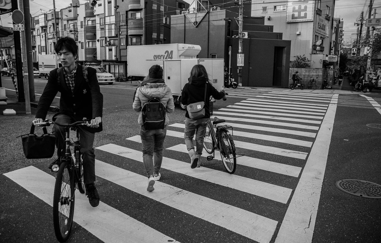 ciclistas atravessam faixa de pedestres
