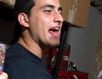 Guy in hat throws dart and almost hits a hand 