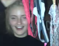 Blonde girl in black turtle neck sweater spins laundry hanger with underwear