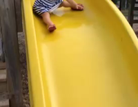 baby sliding down slide and falling down 