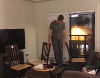 Guy in green shirt tries to do balanced handstand between two chairs falls forward