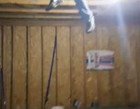 Guy hanging from wood pillars on roof drops onto black table and collapses it