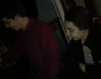 Boy and girl outside struggle to open beer with their heads 