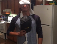 Guy in kitchen has toilet paper on head and ceiling fan 