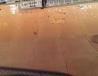 Man in blue white baseball shirt falls off skateboard