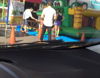 guy in white shirt goes inside green inflatable castle 