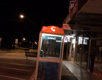 Guy jumps on top of orange telephone booth and falls through
