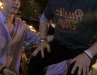 Guy prepares to do a backflip with help from red shirt button down friend but video ends before backflip