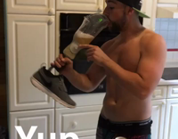 man in hat drinks beer from prosthetic leg