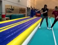 Black Shirt Girl Tumbles Down Blue Yellow Runway Falls On Back