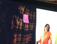 brown dog cuddled in red blanket behind laptop