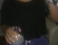 Girl in black holding pepsi downs bottle of vodka