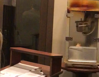 guy behind clear  door being filmed 