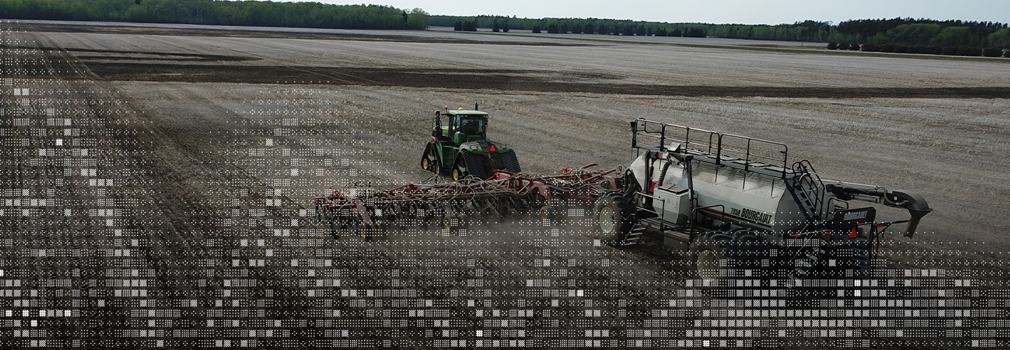 Aerial photo of tractor pulling an air seeder in a field in spring