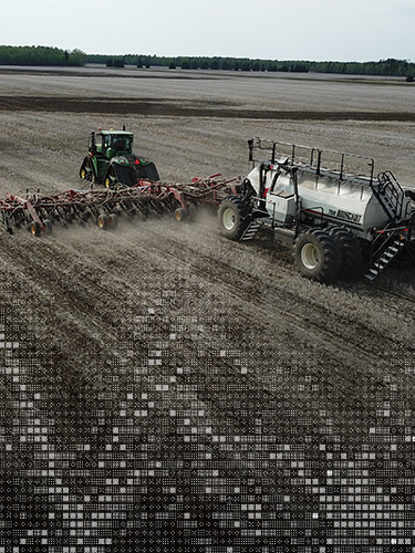 Aerial photo of tractor pulling an air seeder in a field in spring