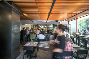 Preview of Mamnoon Street - Image 5: Person, Dining Table, Bench, Wood, Steel, Concrete, Bar, Kitchen, Glass, Window, Storefront, Restaurant.
