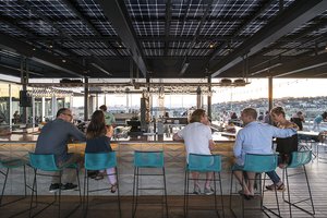 Preview of Mbar - Image 16: Person, Furniture, Restaurant, Wood, Steel, Concrete, Pergola, Structure Steel, Rooftop, Bar, Dining Table, Glass, Window.