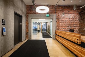 Preview of Undead Labs - Image 20: exposed brick, concrete wall, structural concrete, wood bench, office, modern lighting, adaptive reuse, open space, industrial style, corridor, railing, color.