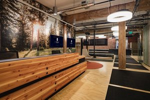 Preview of Undead Labs - Image 8: open floor plan, office, wood paneling, exposed ceiling, industrial style, ambient lighting, pendant light fixtures, glass partition, mural, nature theme, brick wall, concrete floor, structure wood, color.