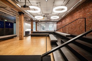 Preview of Undead Labs - Image 4: exposed brick, industrial style, open floor plan, modern lighting, stair, railing, concrete floor, wood, steel beam, large windows, mixed materials, interior design, office space, reflective ceiling panels.