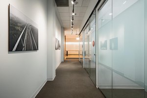 Preview of Undead Labs - Image 6: corridor, track lighting, frosted glass, glass door, pivot door, carpet flooring, interior, wall art, modern design, office space, neutral color palette.