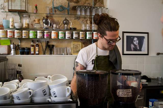 A barista behind the counter in a coffee shop.